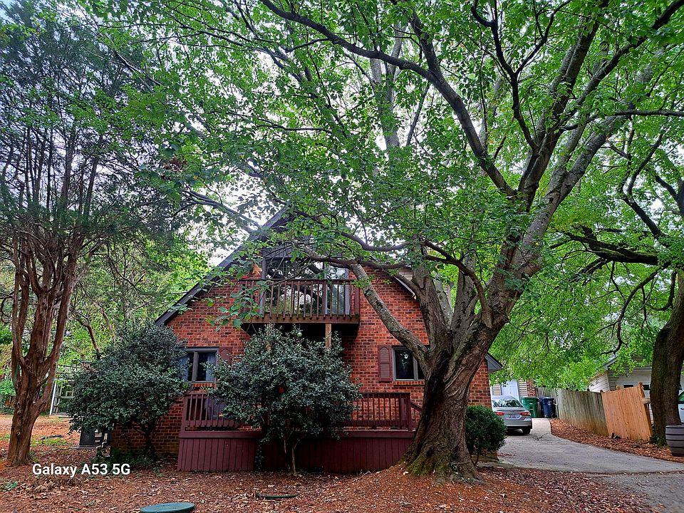 House from front yard. Parking in the driveway, garage or a marked spot in front of the tree.