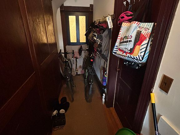 Front hallway with door into living room (right) and glass-paned door into bedroom A (back).