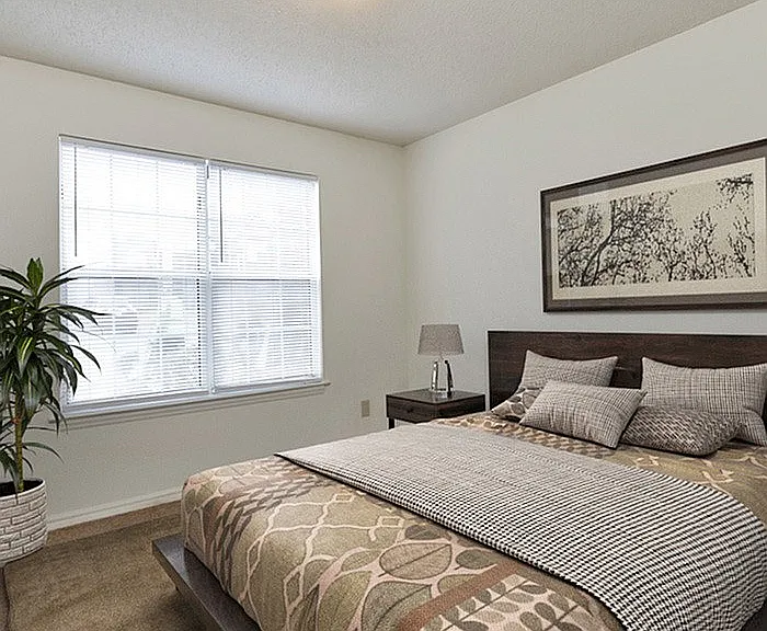 Relax in this serene bedroom, offering ample natural light and sophisticated decor.