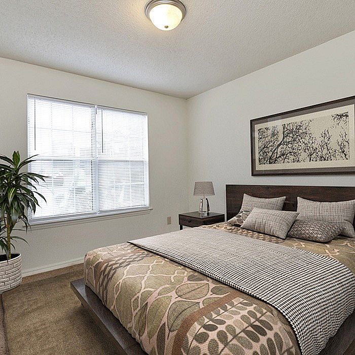 Relax in this serene bedroom, offering ample natural light and sophisticated decor.