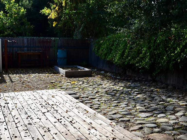 Deck off the master bedroom with raised bed planter at the far side of the garden.