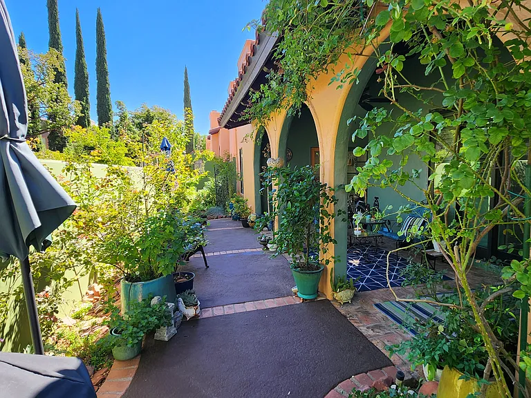 The backyard is a delightful, walled garden full of flowering plants, and provides both a covered sitting area and lovely strolling path.