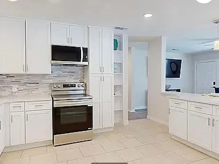 Open kitchen layout with built-in shelving, pantry storage, and clear sight lines to the living area