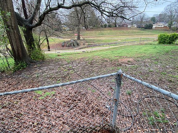 Fenced back yard with city park behind