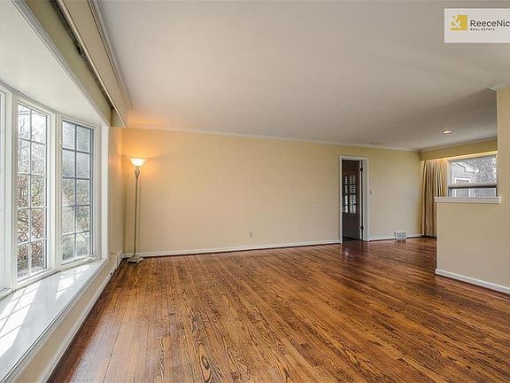 The beautiful Living Room with gleaming hardwood floors and a stunning bay window.