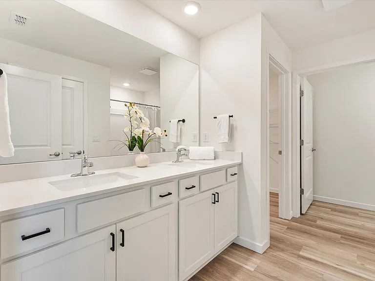 Primary bathroom with double vanities and quartz countertops