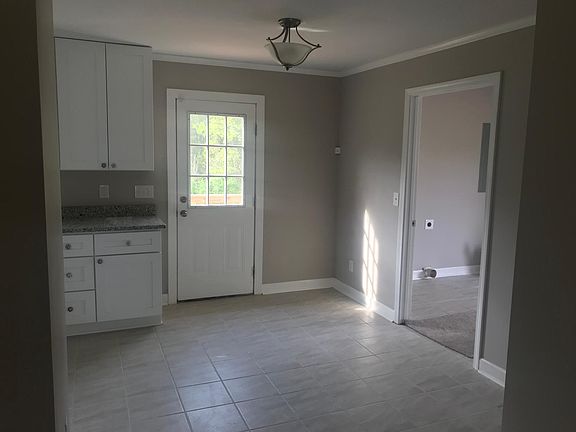 View from living room to dining area. Deck outside door and large laundry room to right.