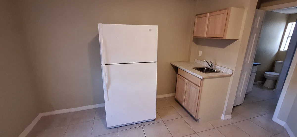Kitchenette with refrigerator, sink, 2 burner countertop stove, and storage. - 3603 E McBerry St #A