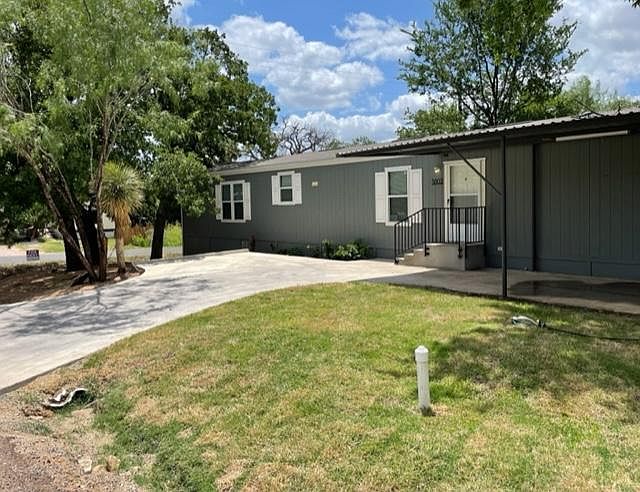 Front of Home on corner lot with carport and plenty of shade tree's.