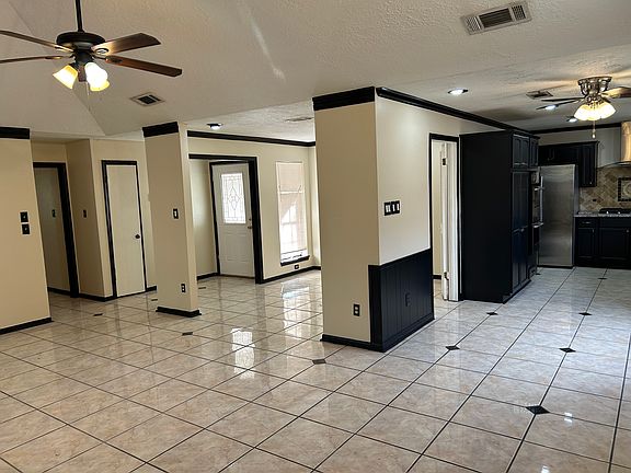 View 2 of the living room, also looking at the kitchen (right side), dining room and the front door.