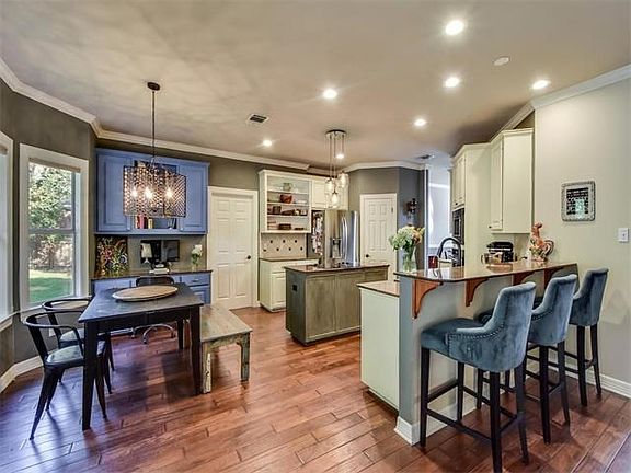 The updated kitchen features open cabinetry, stainless steel appliances and granite counter tops.