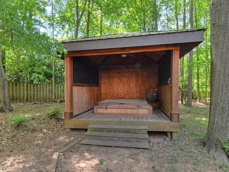 Back of the house and gazebo. There is a hot tub, not available for use in the gazebo. (It doesn't work.). There is a cover on it.