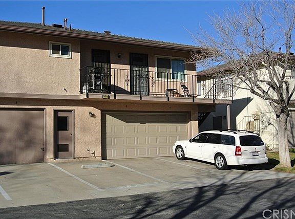One covered garage parking space and one uncovered parking space on far right.