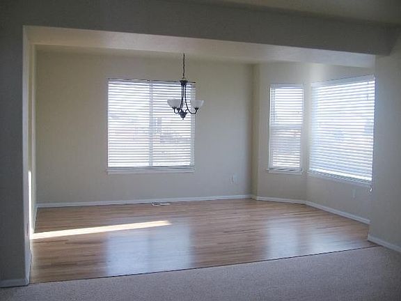 Formal dining room with hardwood floors and bay window.