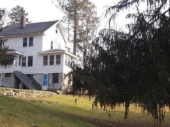 View of the back of the house, with stairs going up to a small enclosed porch/mud room.