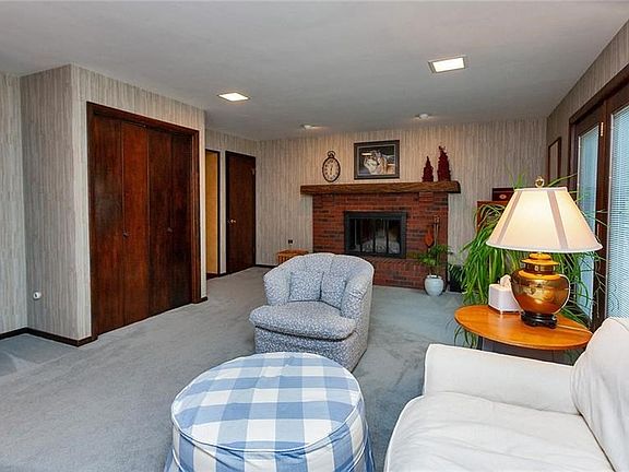 Entertain easily in this family room with a brick, log burning fireplace with a rustic mantle.