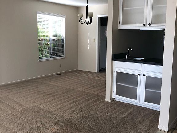 Living room with vaulted ceiling and formal dining room from front entryway,