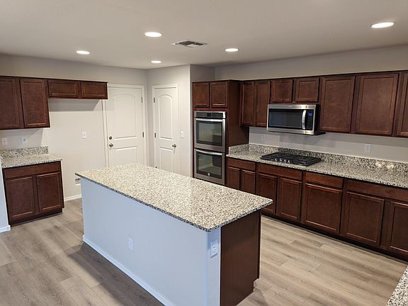 Downstairs Kitchen with double ovens, built-in microwave, and flat cook top.