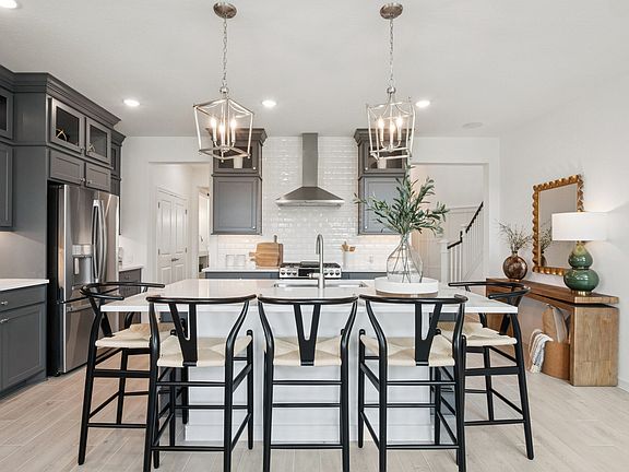 Kitchen showcases stacked cabinetry with glass-front uppers