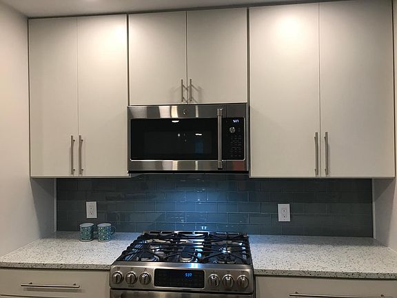 Glass backspash highlights stainless steel gas cooktop & Microwave/convection oven.