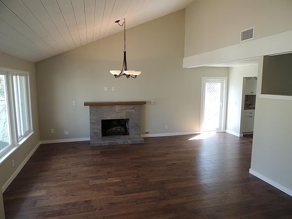 Living room with gas burning fireplace and door to side yard