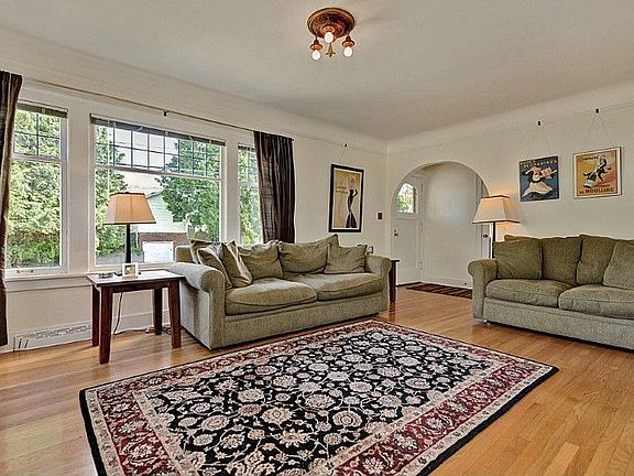 Front entry with coat closet, bright spacious living room with tiled fireplace, original architectural detailing and fixtures, Oak hardwoods and leaded glass windows.