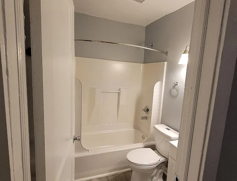An updated bathroom featuring hotel-style fixtures and clean, modern lighting.