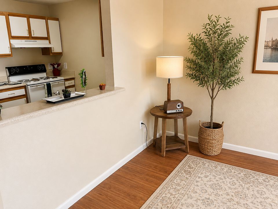 Open living spaces. Living area featuring wooden floors looking into kitchen.