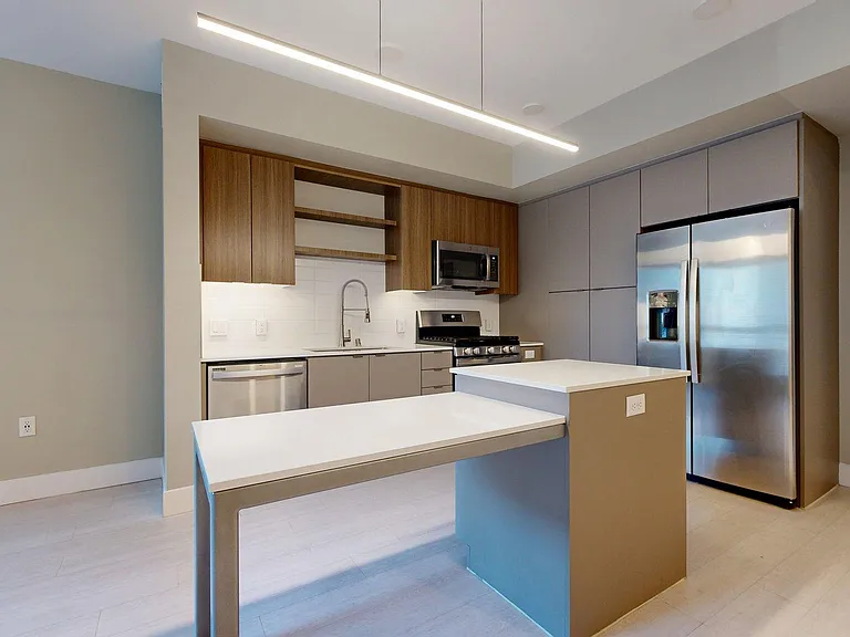 Apartment Kitchen with Quartz counter tops and Wood-Style Flooring.