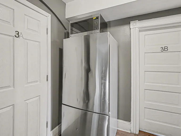 Convenient common-area alcove with a full-size refrigerator and microwave, located near interior entry doors for easy access.