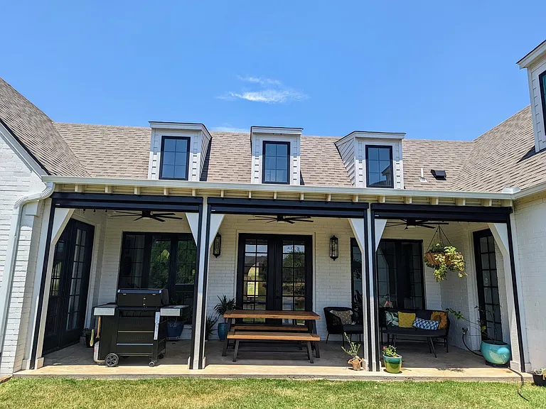 Relaxing back patio space with outdoor seating, a grill, ceiling fans, string lights, and automatic screens to block bugs and sunlight.