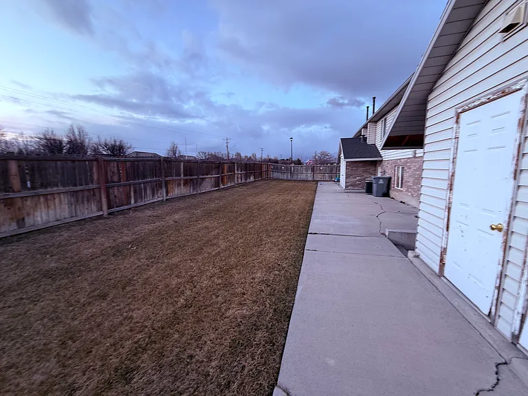 View of shed on right and back yard extending behind other units.