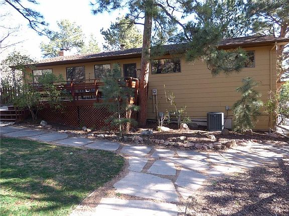 rear of home with large deck and beautiful trees, home has A/C