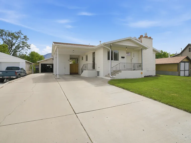 Angled Front of House with view of Carport and Detached Garage