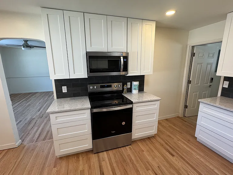Kitchen with new appliances, cabinets and backsplash/counters/countertops.