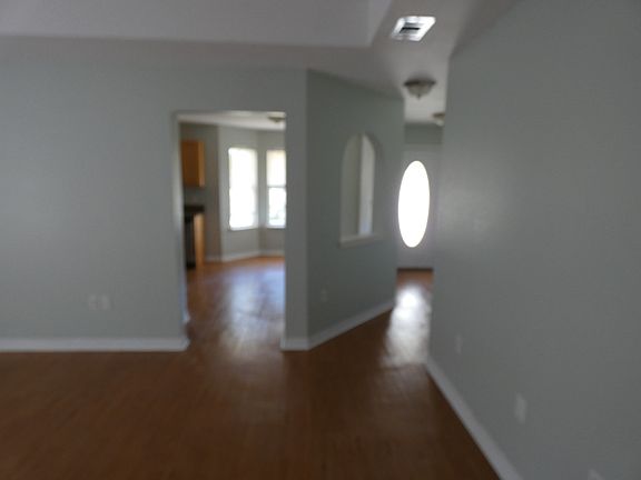living room look though haul way to front door and dining