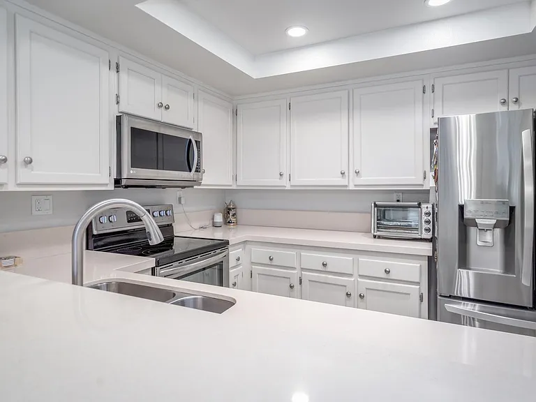 Well-lit kitchen with abundant cabinet and countertop space
