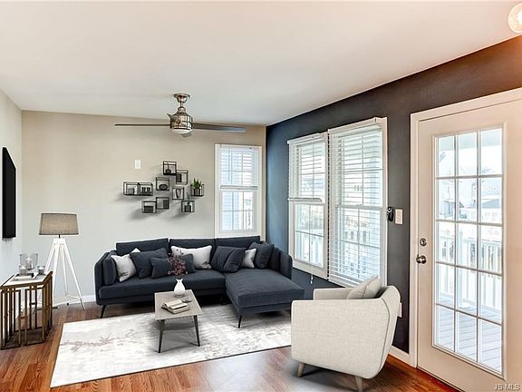 Virtually staged living room with access to a deck overlooking the lagoon