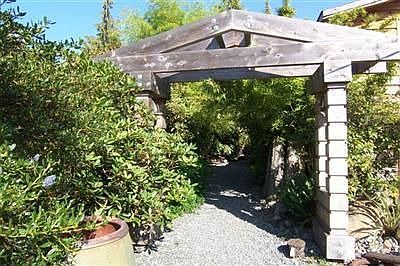 Custom cedar entry gate wtih filtered light under a wonderful canopy of timber bamboo, lead you to t