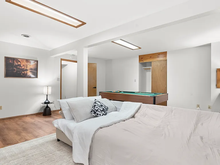 Flexible basement bedroom/lounge with a convertible sofa for comfortable seating or sleeping with pool table.