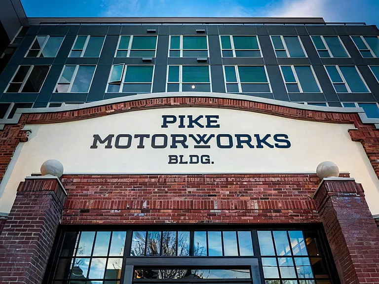 Exterior View of Pike Motorworks Entrance with Signage and Upper Windows