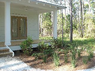 View of Master bedroom french doors and patio from back yard. 