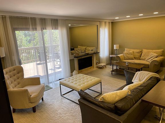 Furnished living room with fireplace & adjoining deck