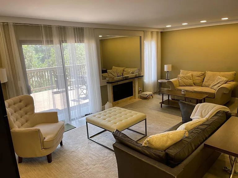 Furnished living room with fireplace & adjoining deck