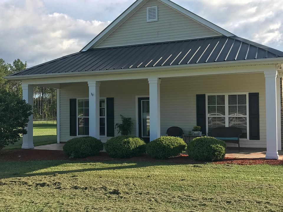 Beautiful covered front porch looks out onto a peaceful field. Barn swallows dart around the property during the day and a symphony of frogs can be heard in the evening.