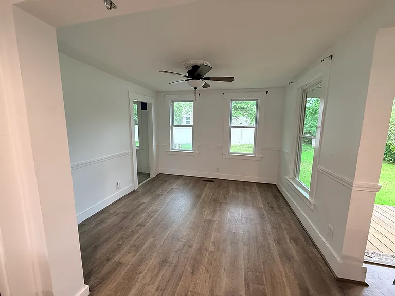 Living area just off the kitchen. Door to first floor bedroom in the back.