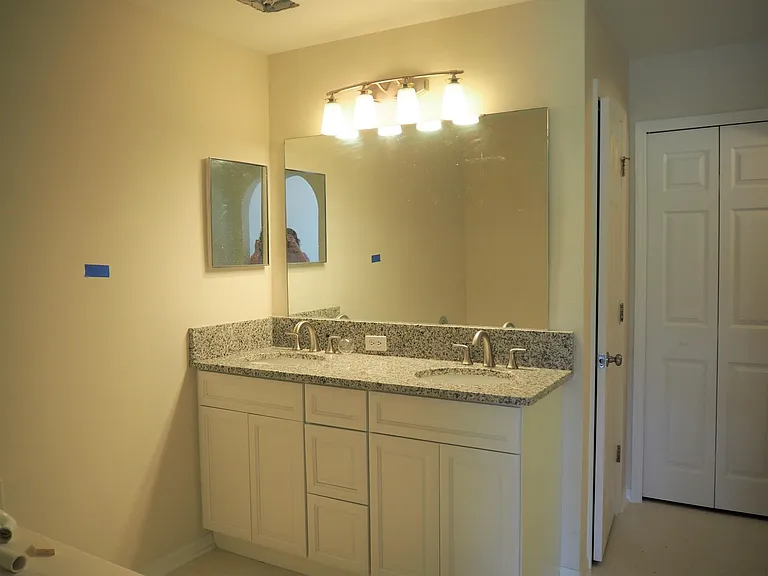 Master bath with new vanity and granite tops, Soaking tub is in the foreground, the single door leads to commode and shower and the double door is a linen closet.