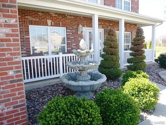 Concrete Water Fountain Surrounded by Artistic Landscaping and Shrubbery