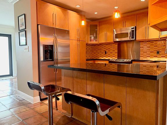 Solid wood cabinets, black galaxy granite counter tops, glass tile backsplash and GE Profile appliances (Fridge, Microwave, cooktop & dishwasher).
