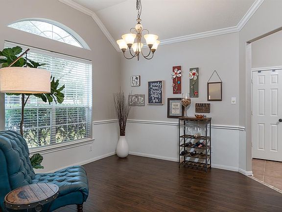Just off of the entry is the dining room, connected to the kitchen for easy entertaining! It boasts high ceilings, chair & crown molding, and a large picture window with arch above that allows the natural light to flow into the space!